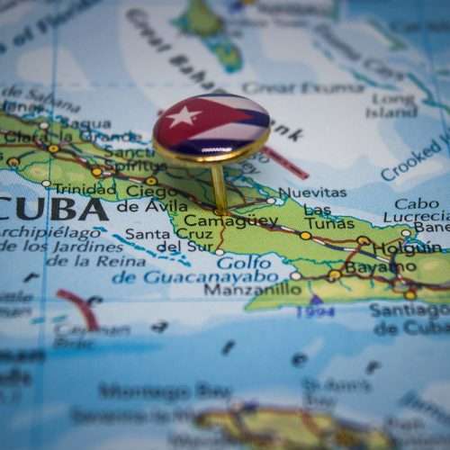 Map of Cuba with a signet ring denoting the Cuban Flag pinned in the centre