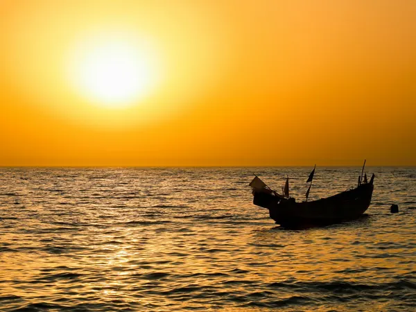 Fishing pirogue off the Petite Cรดte at sunset
