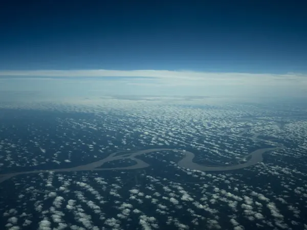 The Amazon seen from the air, meandering through the forest below the clouds (no credit-free photo of Macapรก exists)